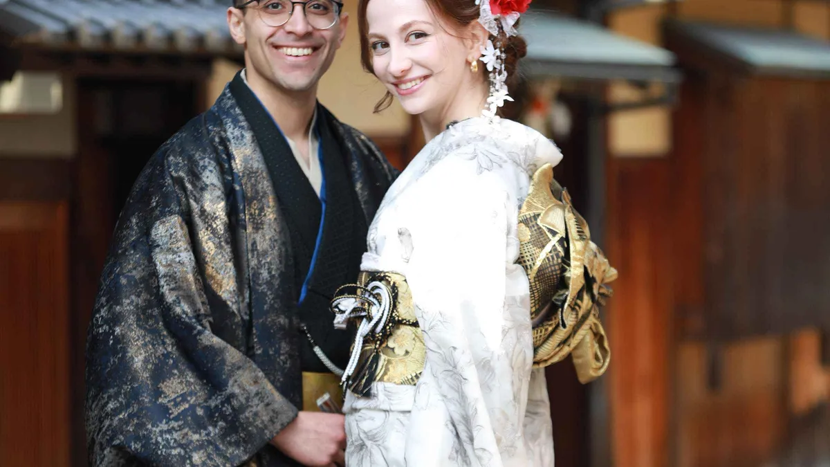 Friends laughing with paper parasol props during a playful Kyoto photoshoot session in a traditional lane, Kyoto